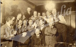 Bietrinkende Männergruppe mit Dame (Um 1920)