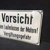 Vorsicht beim Laufenlassen der Motore! Vergiftungsgefahr (Gewölbtes Emailleschild um 1950)